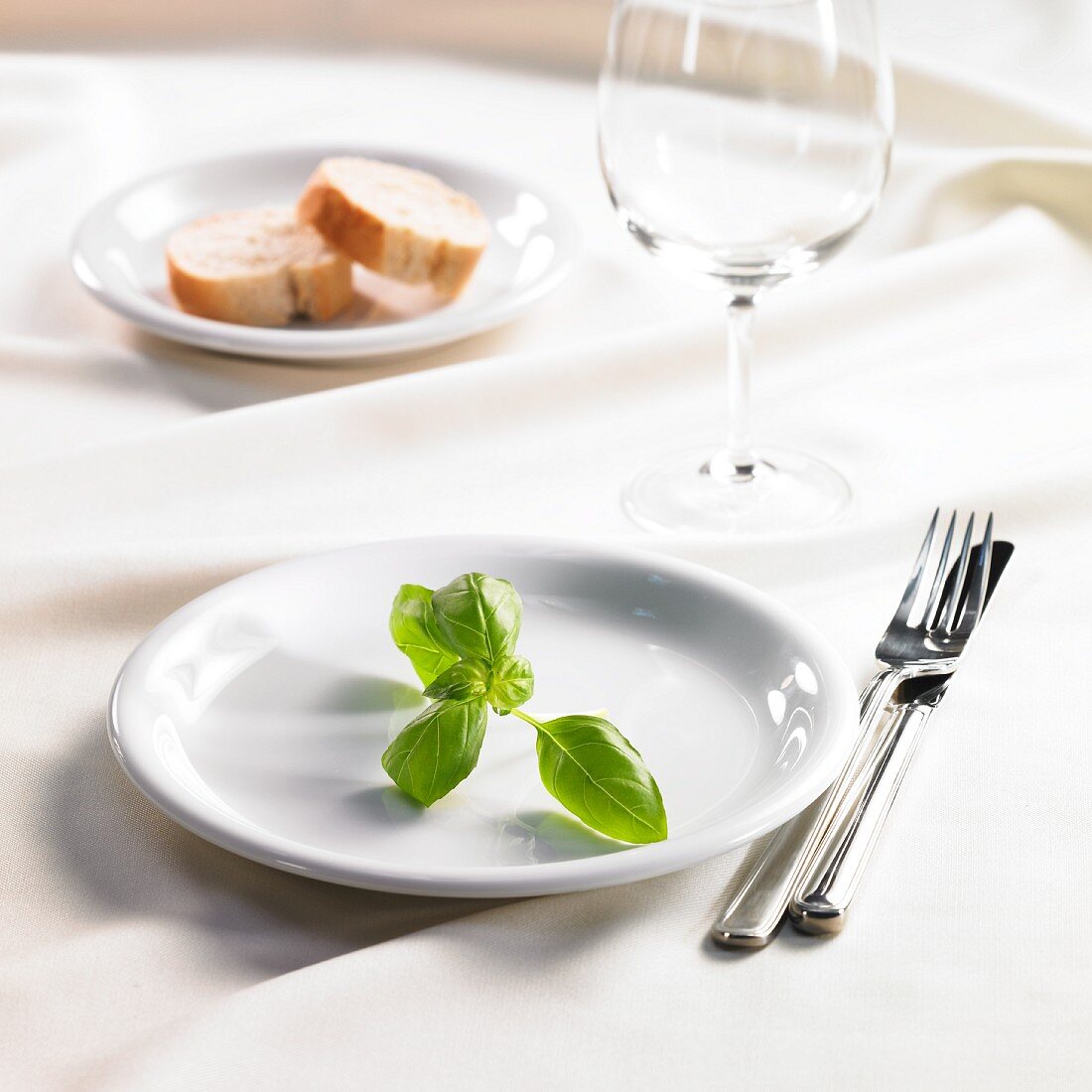 Tischszene mit Basilikum und Weißbrot