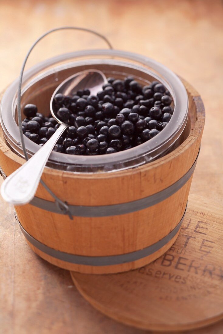 A bucket of blueberries in a small wooden barrel