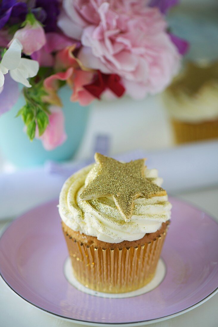 A cupcake decorated with a golden star