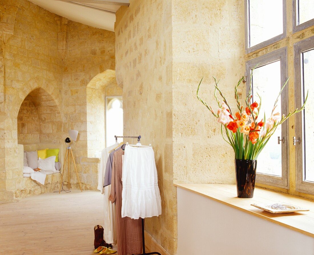 Interior with seat in niche with cushions & standard lamp in Château Maignaut (Pyrenees, France)