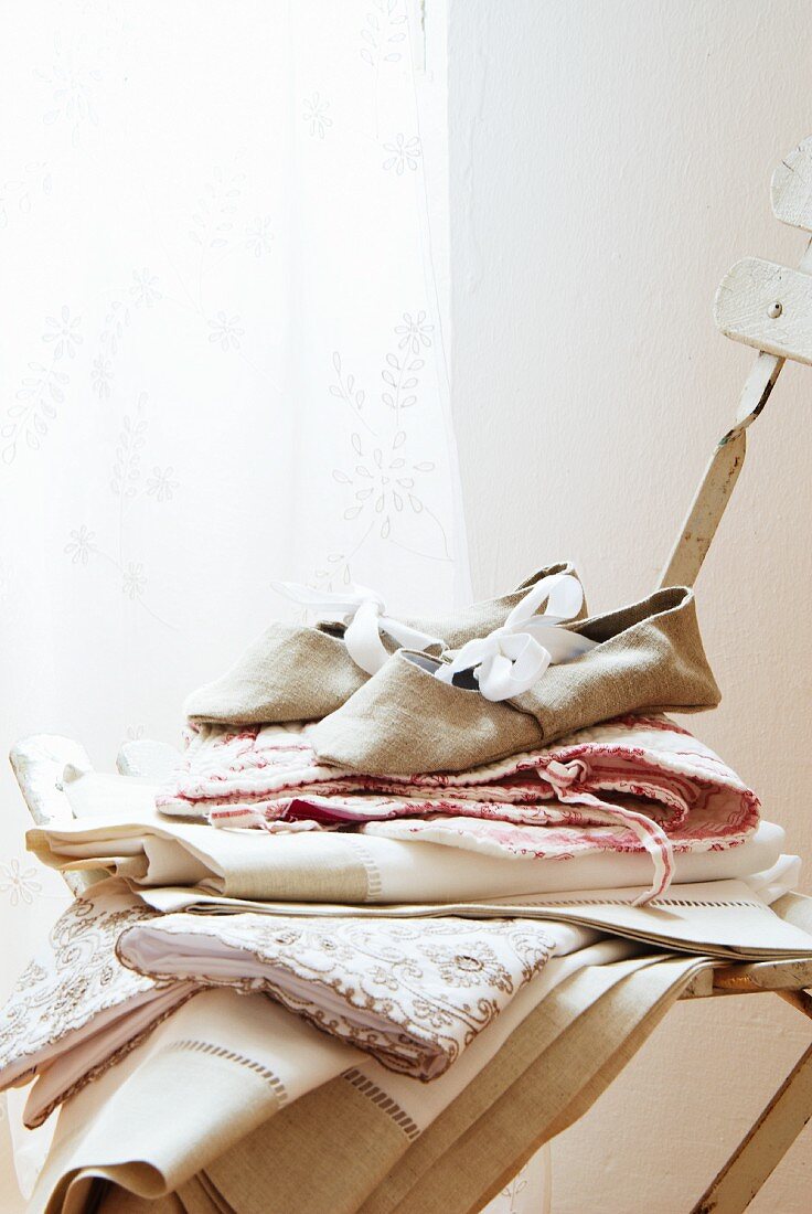 Linen bedding & linen slippers on chair in Château Maignaut (Pyrenees, France)