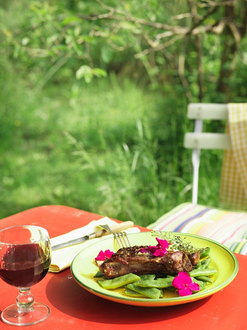 Steak mit grünen Bohnen und Essblüten im Garten