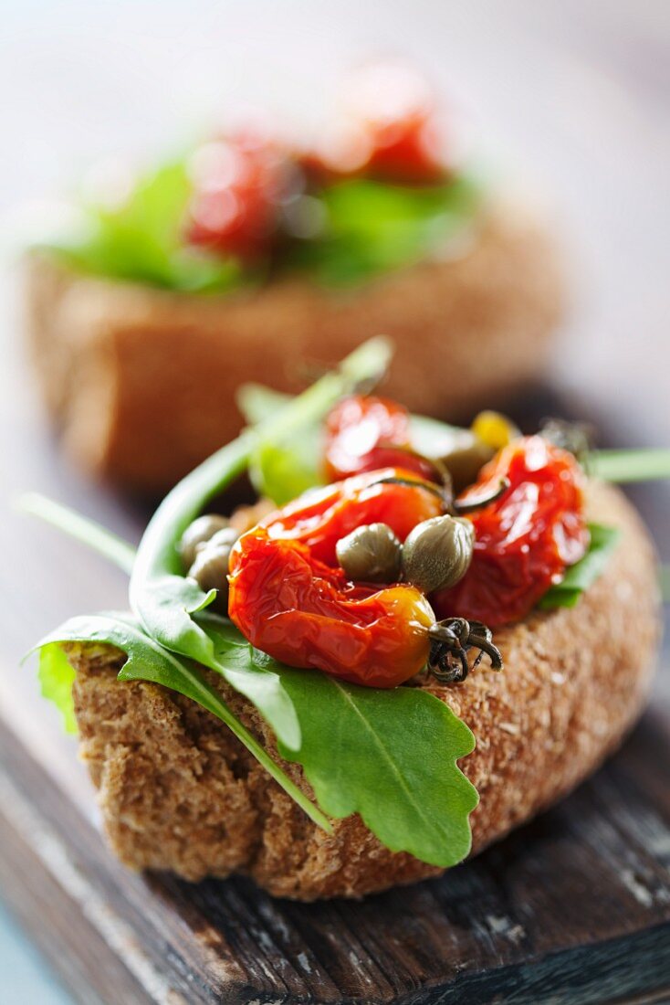 Crostini campagnoli (toasted bread topped with tomatoes, capers and rocket)