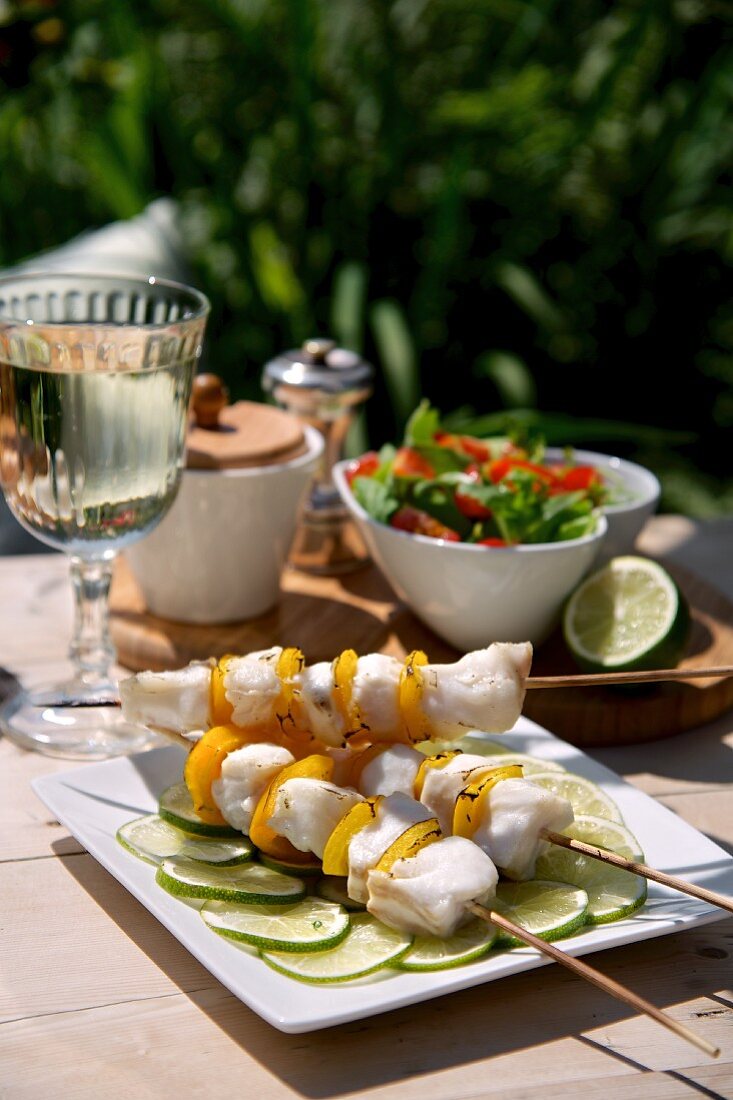 Fish skewers on slices of lime