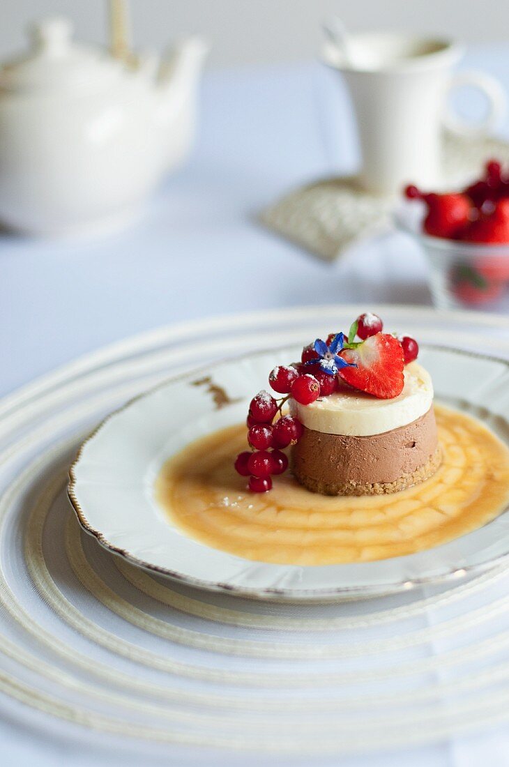 Kleiner Schokoladen-Vanille-Käsekuchen mit Karamellsauce und Beeren