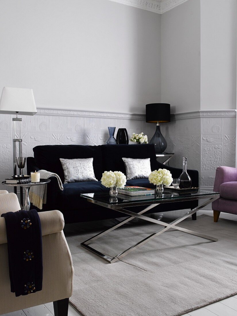 Wohnzimmer mit Sofa, Teppich, Tischlampen und Glastischen