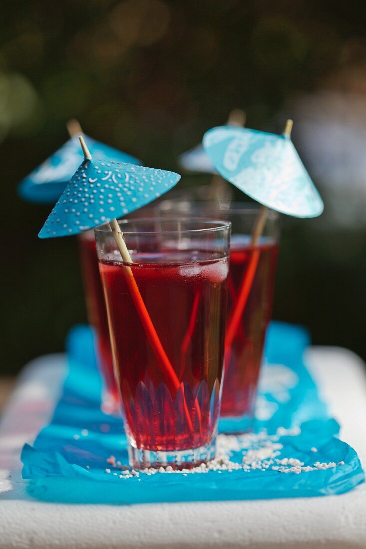 Rote Sommerdrinks mit blauem Schirmchen