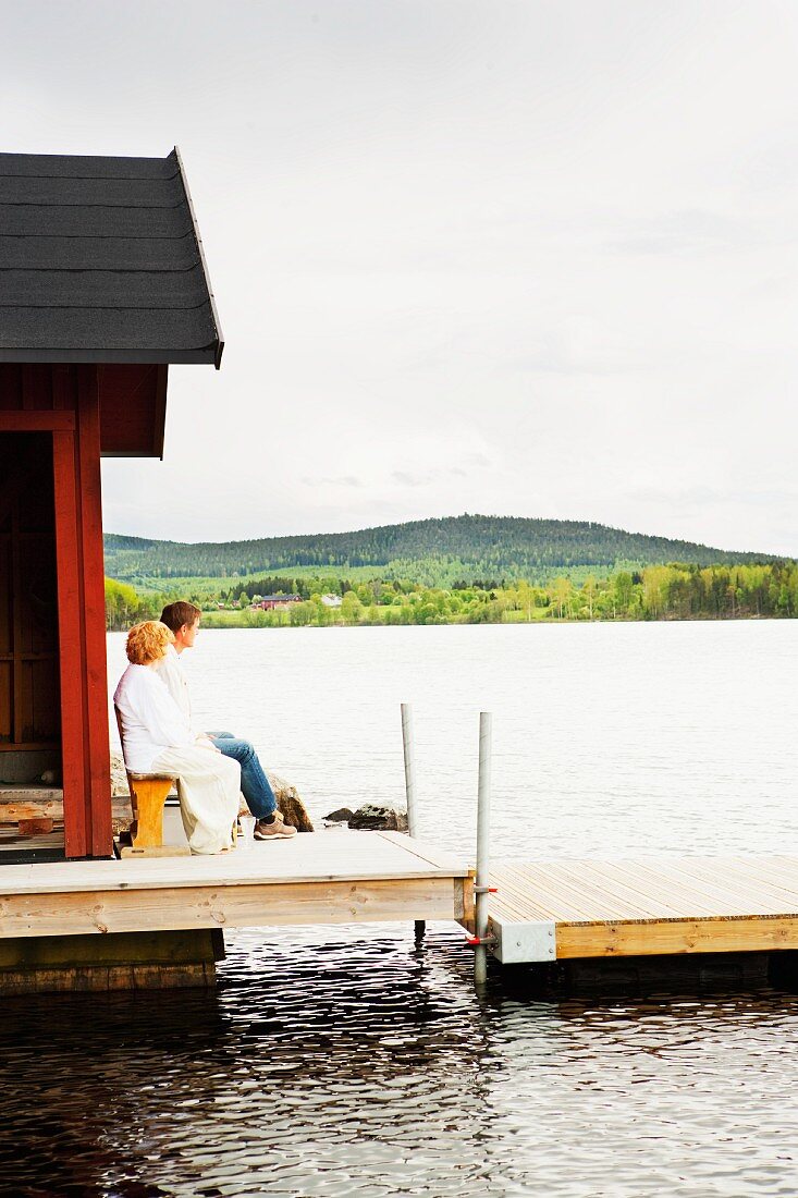 Couple enjoying the evening sun outside a boat house