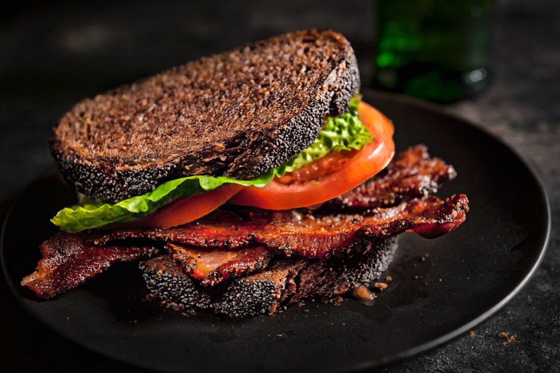 Rustikales Vollkornsandwich mit knusprigem Speck, Tomaten und Salatblatt