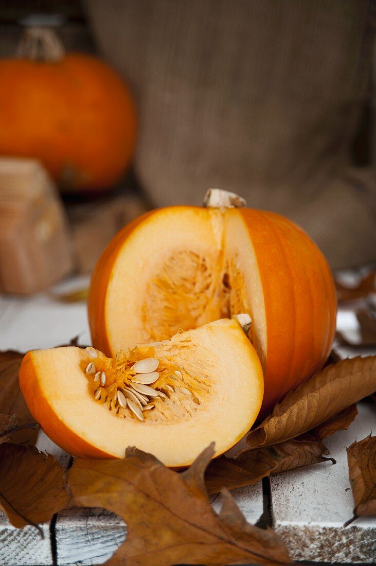 Angeschnittener Kürbis auf Herbstblättern