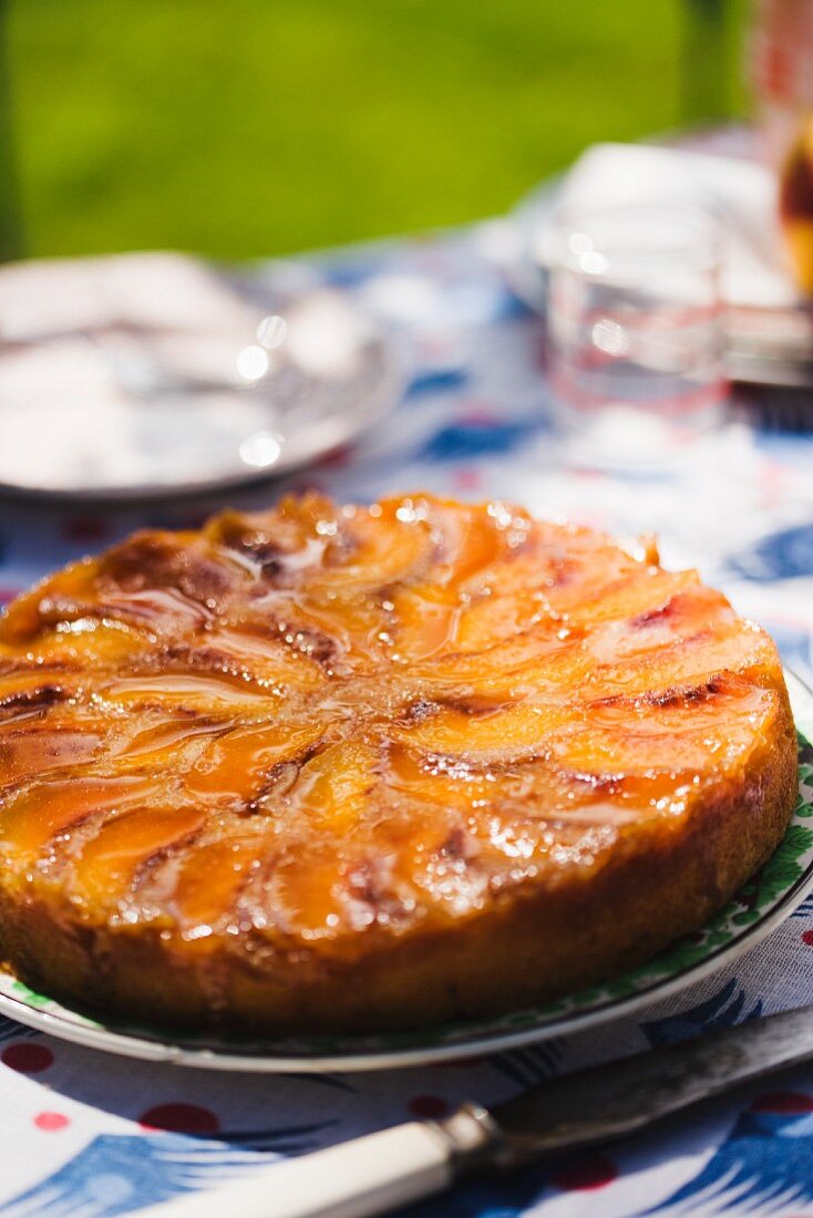 Whole Peach Upside Down Cake on a Sunny Outdoor Table