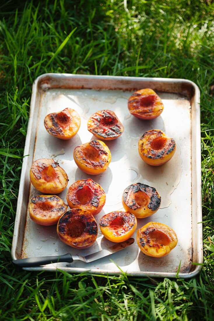 Pan of Grilled Peach Halves on the Grass