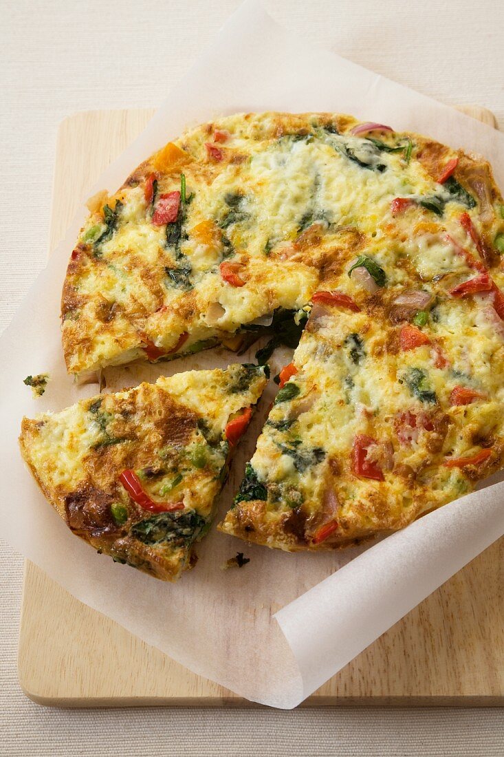 Vegetable Spanish Tortilla with Slice Removed; On a Cutting Board