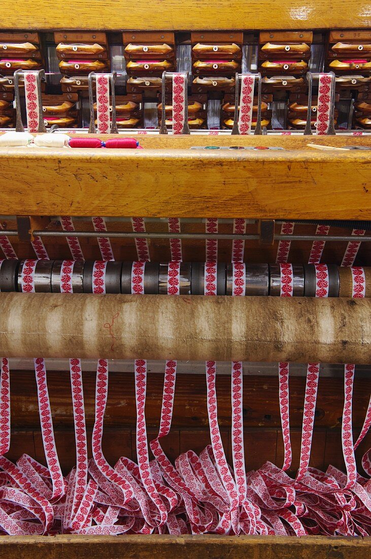 Finished fabric ribbons emerging from loom