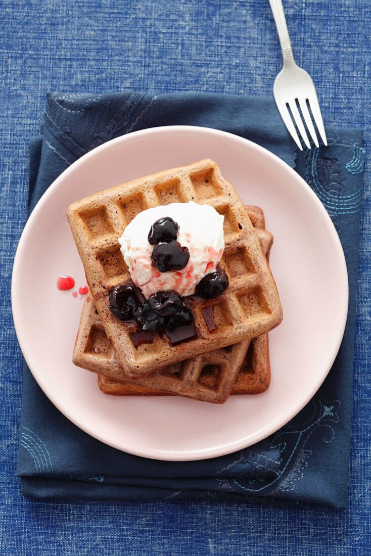 Chocolate waffles with cherries and cream