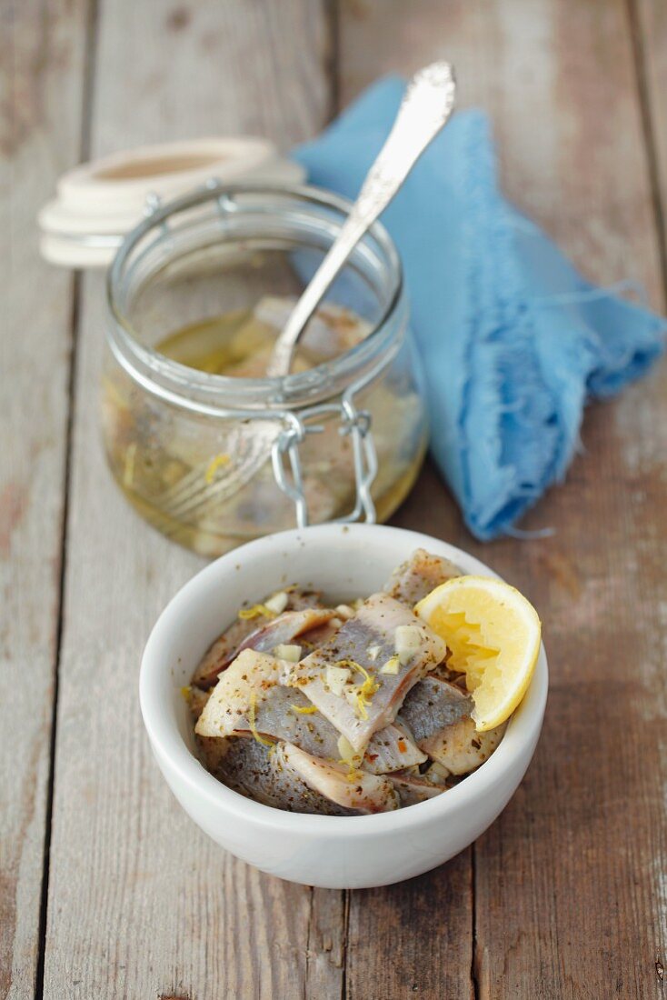 Preserved herrings in oil with lemons, garlic and marjoram