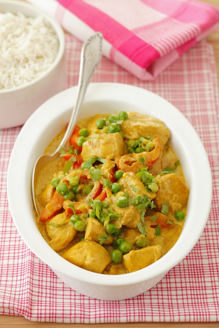 Chicken curry with peas and peppers with a side of rice