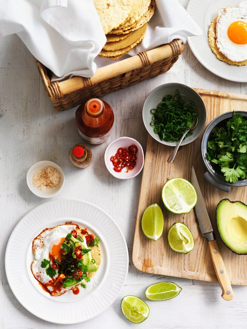 Tacos mit Spiegelei, Avocado, Chilischoten, Koriandergrün und Limetten