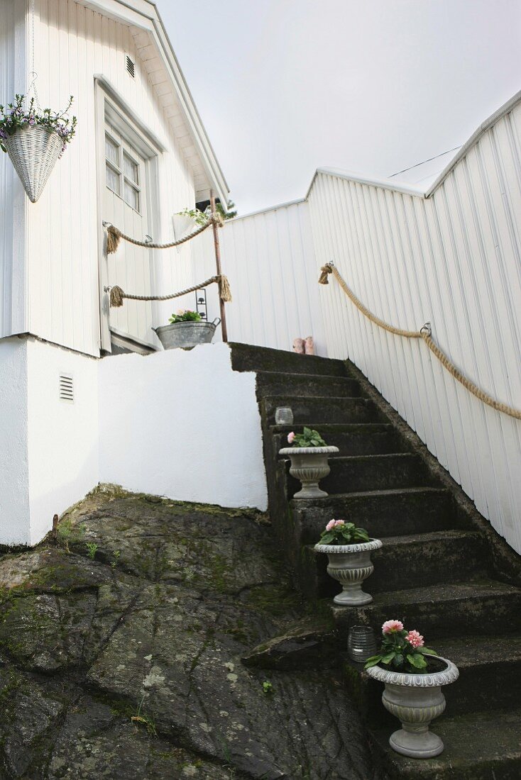 Urns of flowers decorating stone steps leading to front door