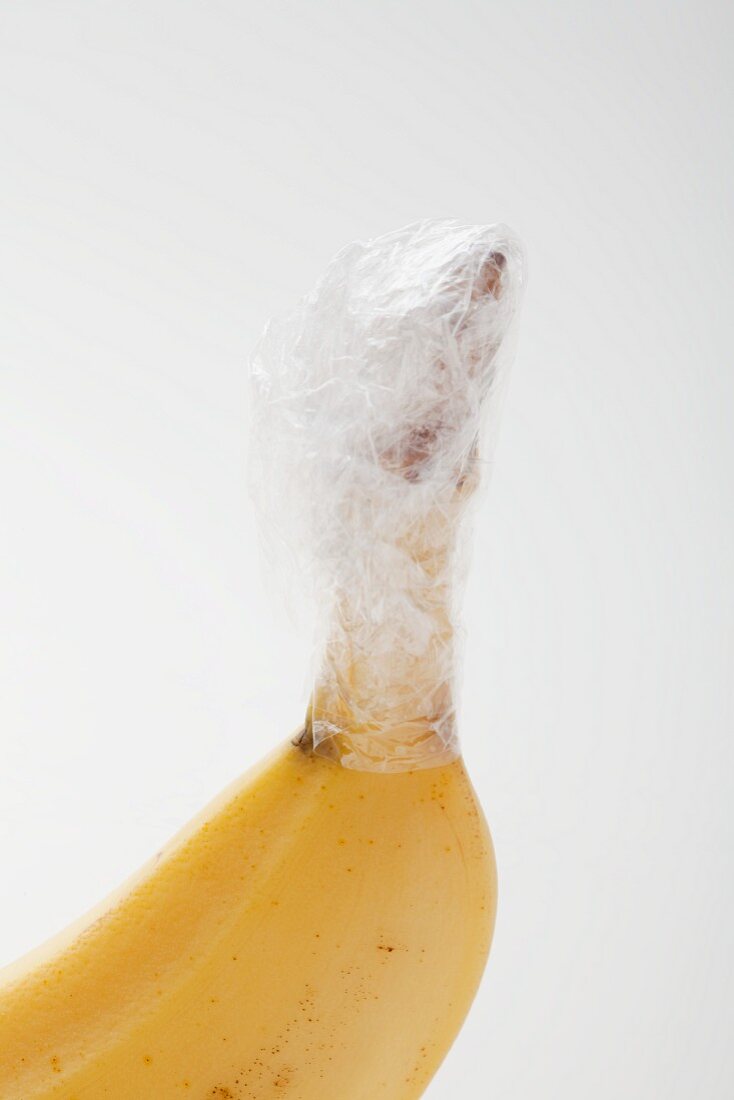 A banana with the stem wrapped in cling-film to keep if fresh for longer