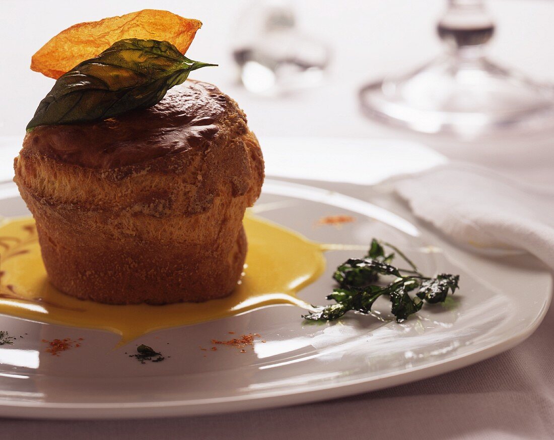 A cheese soufflé with fontina cheese sauce and caramelised herbs