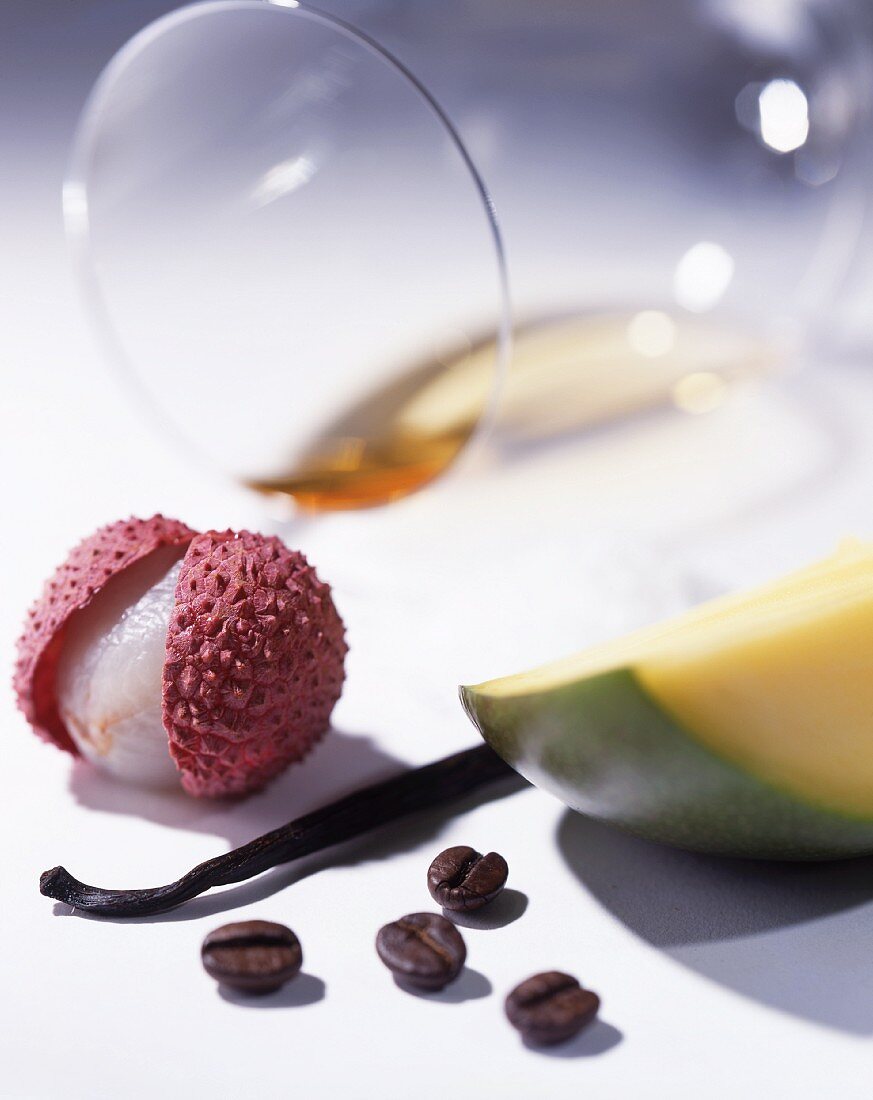 White wine, a lychee, a vanilla pod, coffee beans and a portion of mango