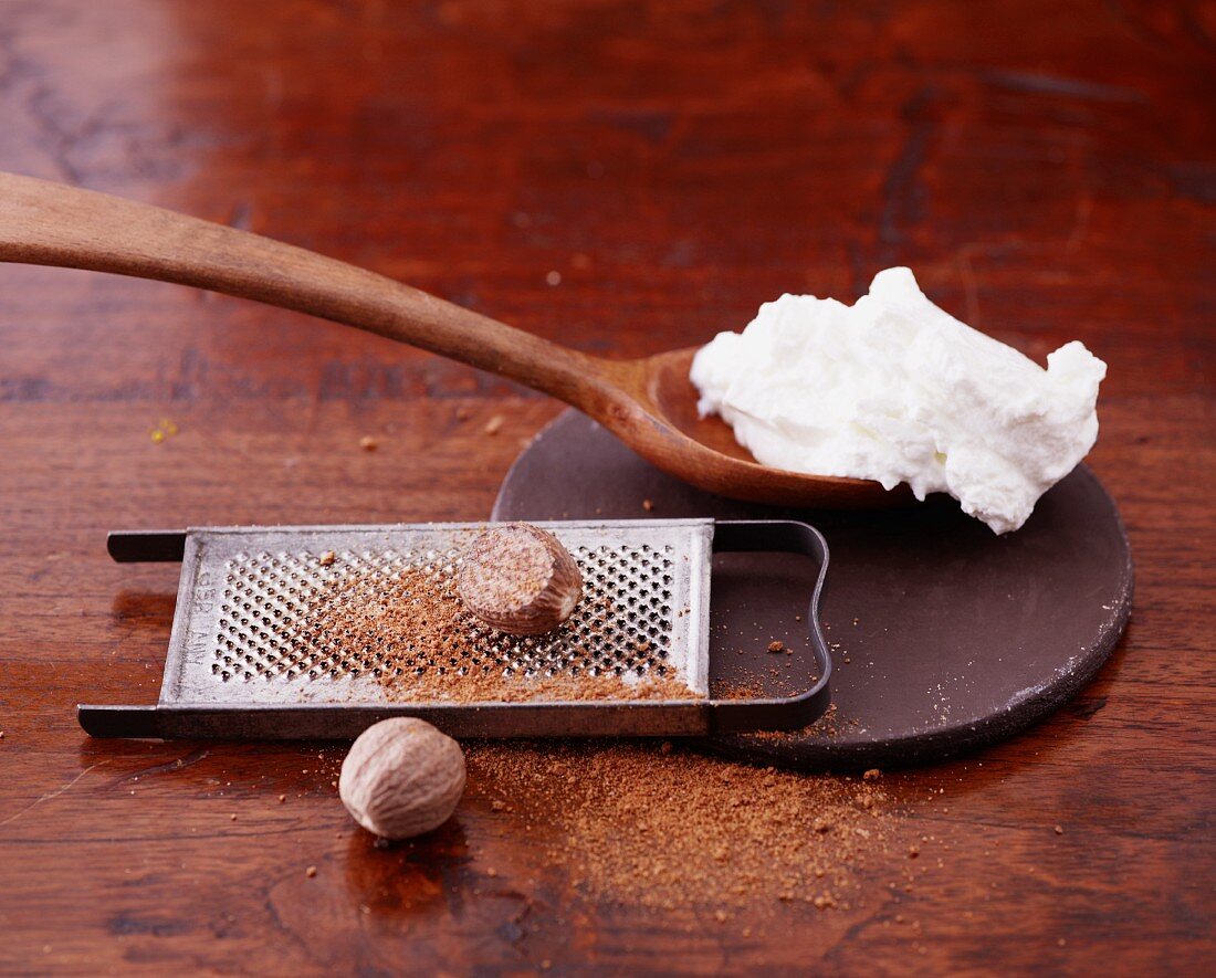 Quark on a wooden spoon and nutmeg on a grater