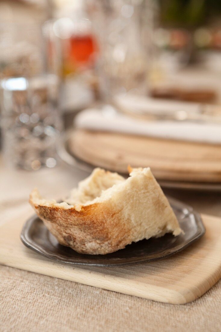 A chunk of white bread on a pewter plate