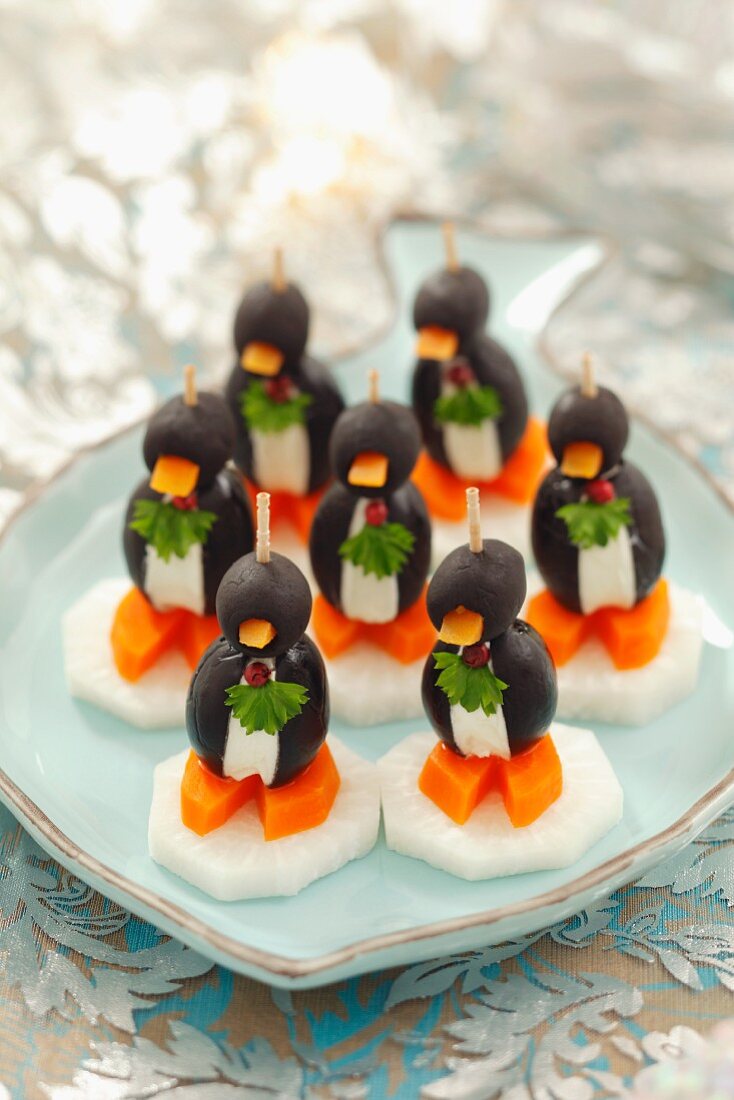 Olive penguins with cream cheese, carrots and radishes