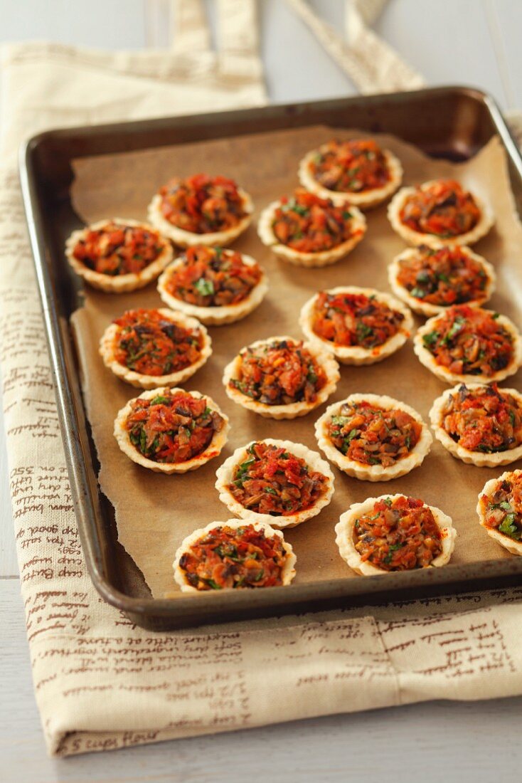 Torteletts mit Schinken und Pilzen auf dem Backblech