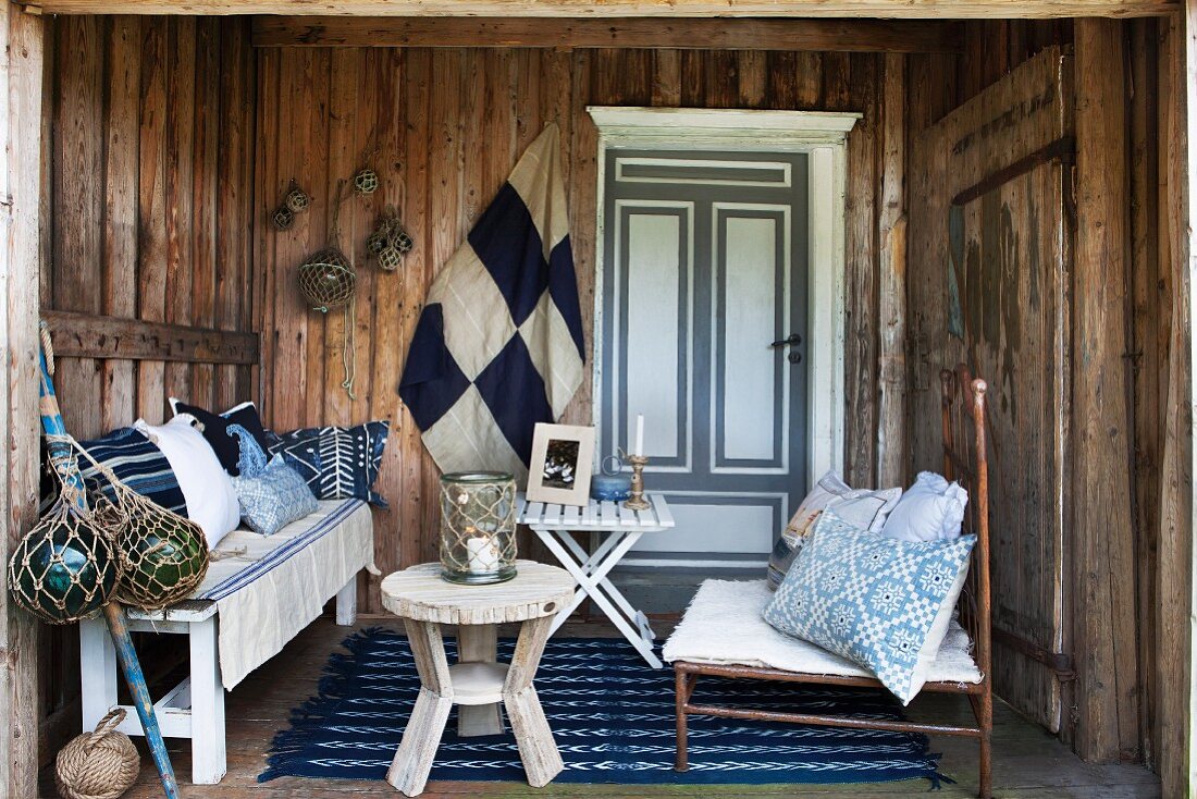 Cosy, maritime decor in porch of wooden house