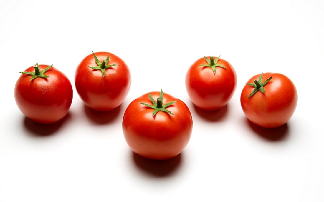 Fünf Tomaten auf weißem Untergrund