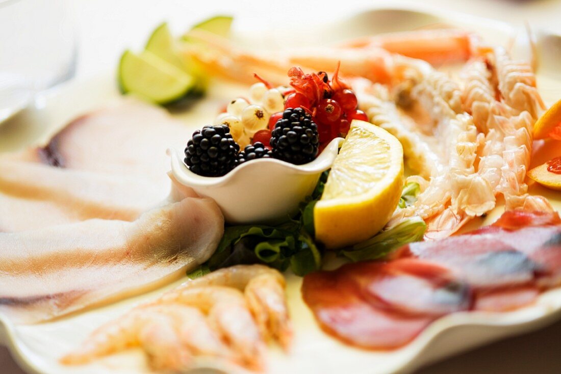 A plate of mixed starters with prawns and carpaccio of tuna and of swordfish