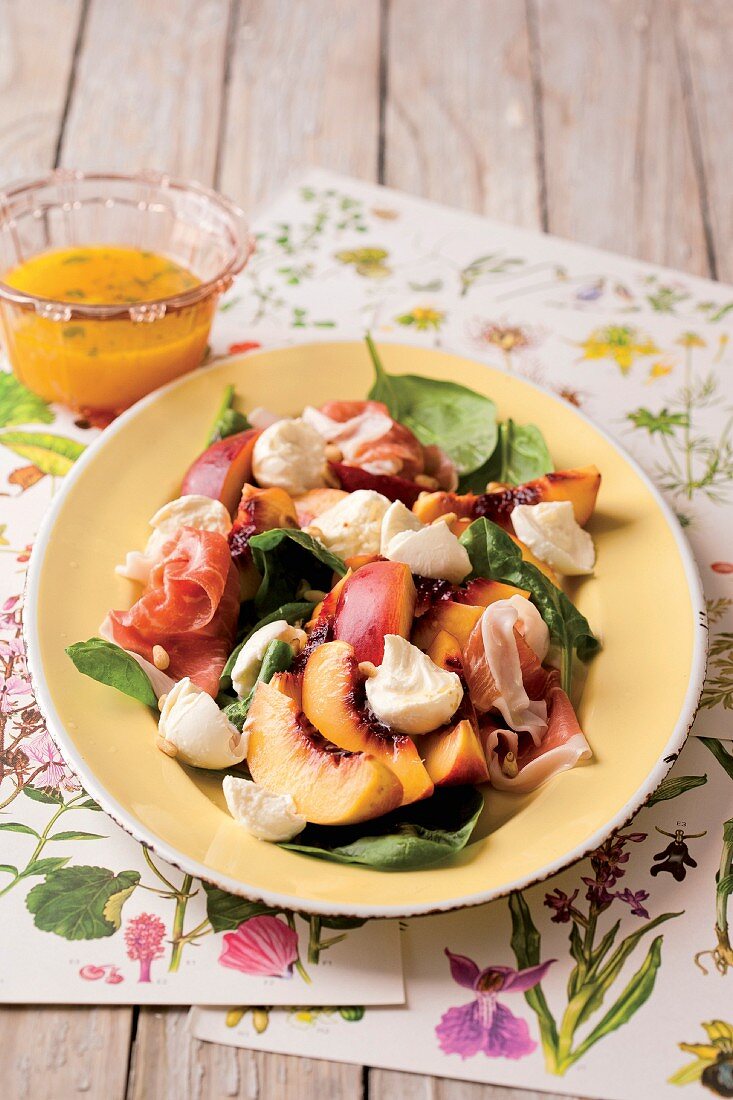 Spinach salad with mozzarella, ham and peaches