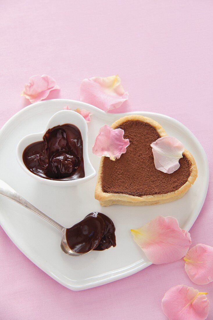 A heart-shaped mini chocolate torte with pink rose petals