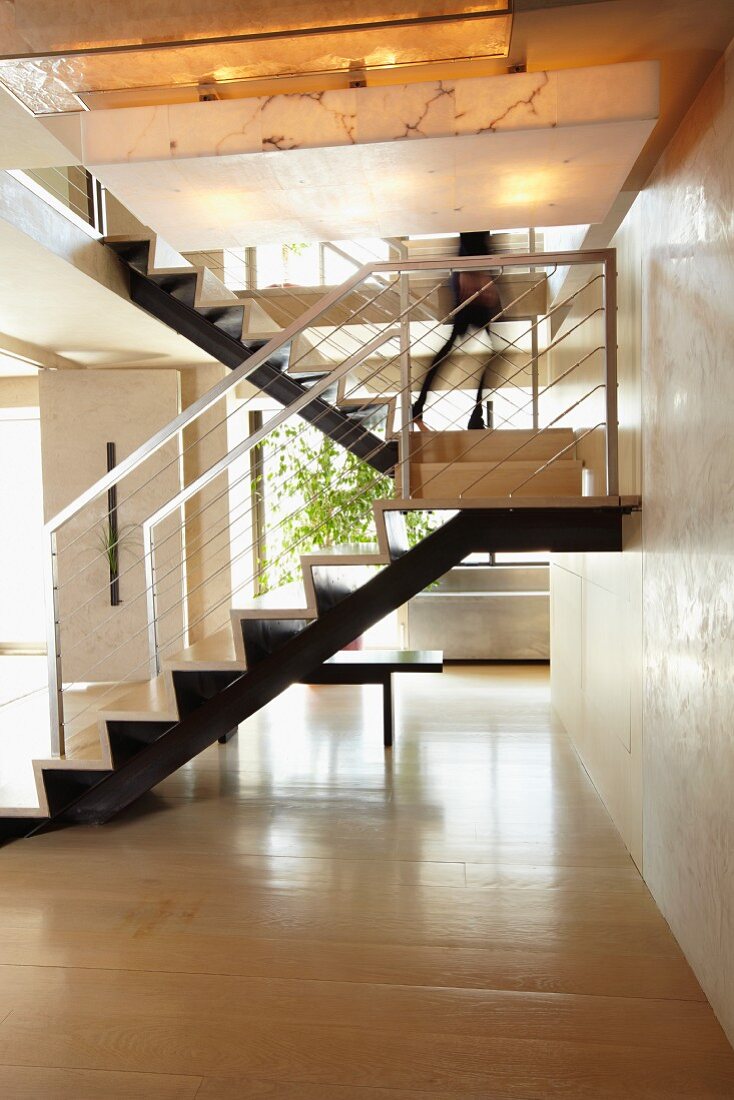 Modern metal staircase with light wood flooring in the open living room