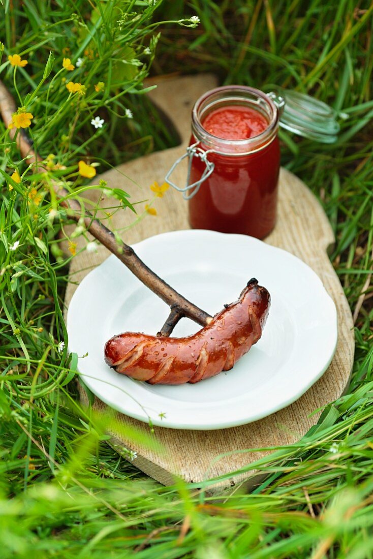 A sausage cooked over an open fire with home-made ketchup