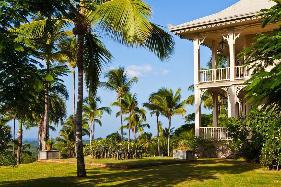 Mehrstöckiges Hotel in elegantem Kolonialstil mit umlaufender Veranda in Palmengarten