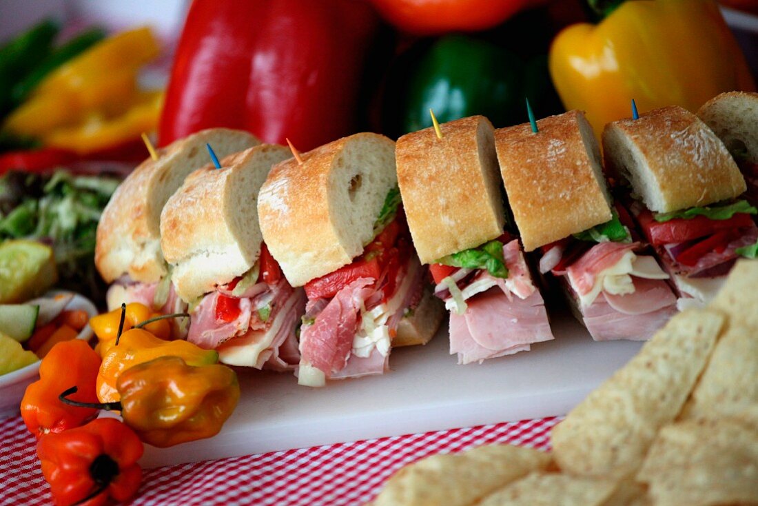 Party Sub Sliced with Toothpicks; On a Cutting Board; Peppers and Chips