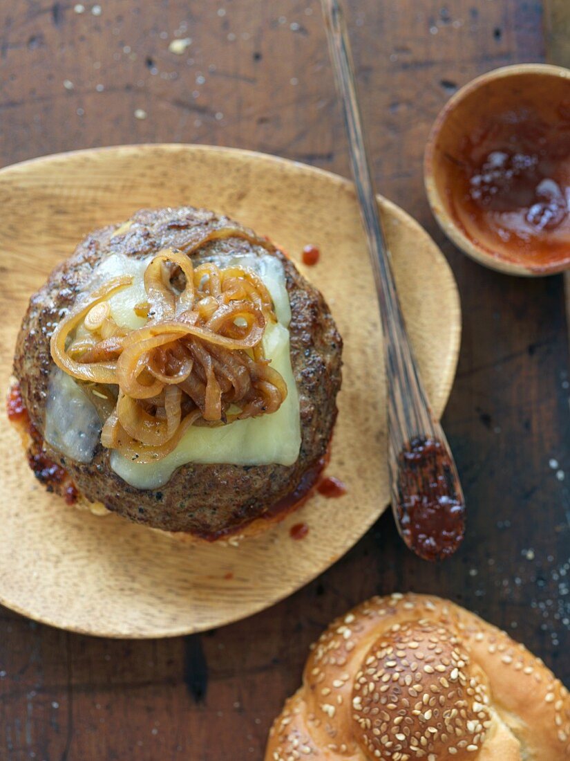 Aufgeklappter Cheeseburger mit karamellisierten Zwiebeln und Barbecuesauce