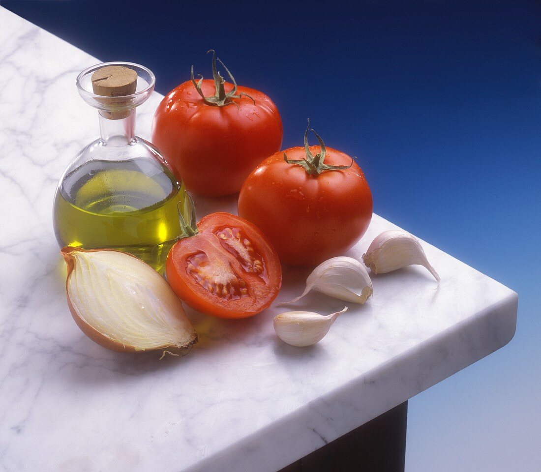 A still life of tomatoes, olive oil and garlic