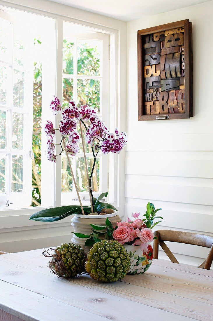 Flower arrangement on table in front of open window