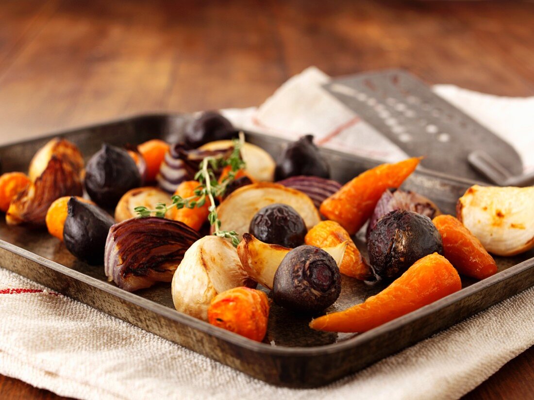 Roasted onions, carrots and beetroot on a baking tray