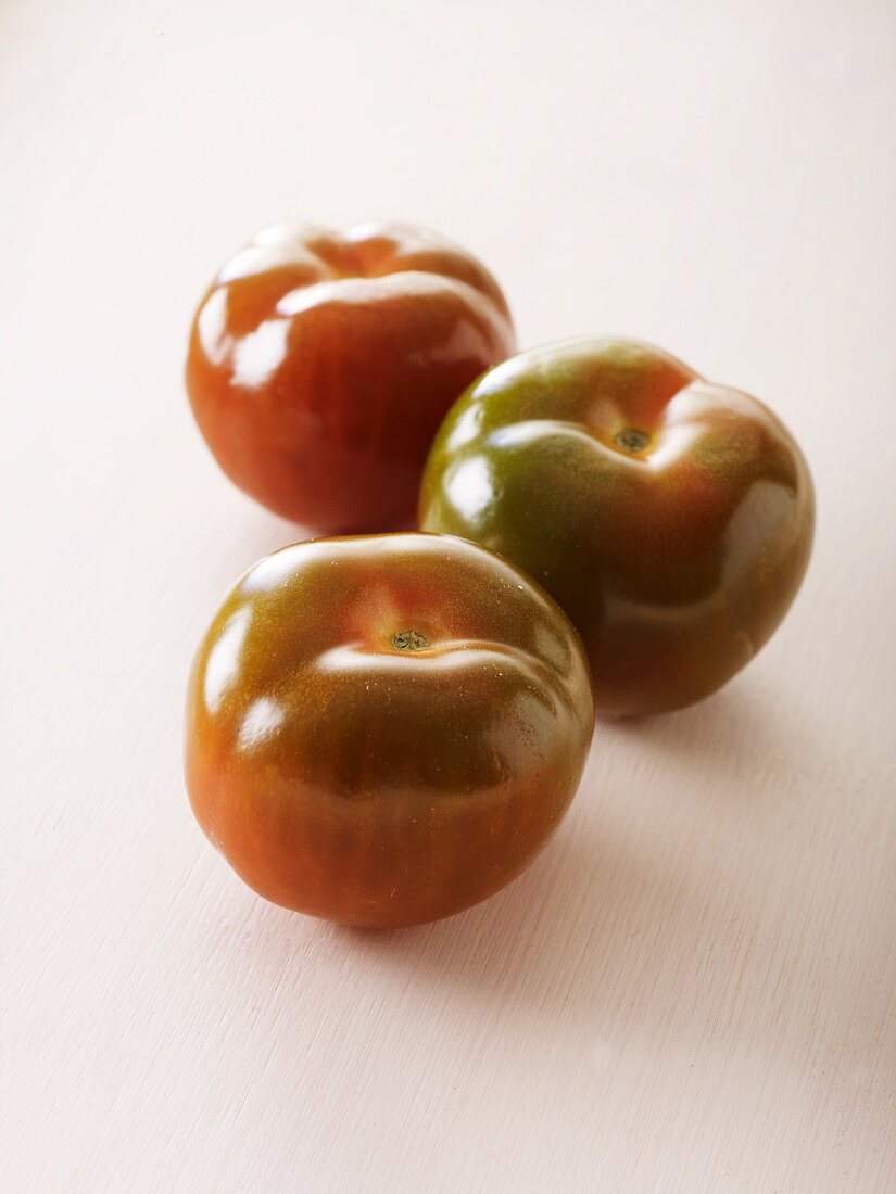 Drei kleine Tomaten der Sorte Noire De Crimee