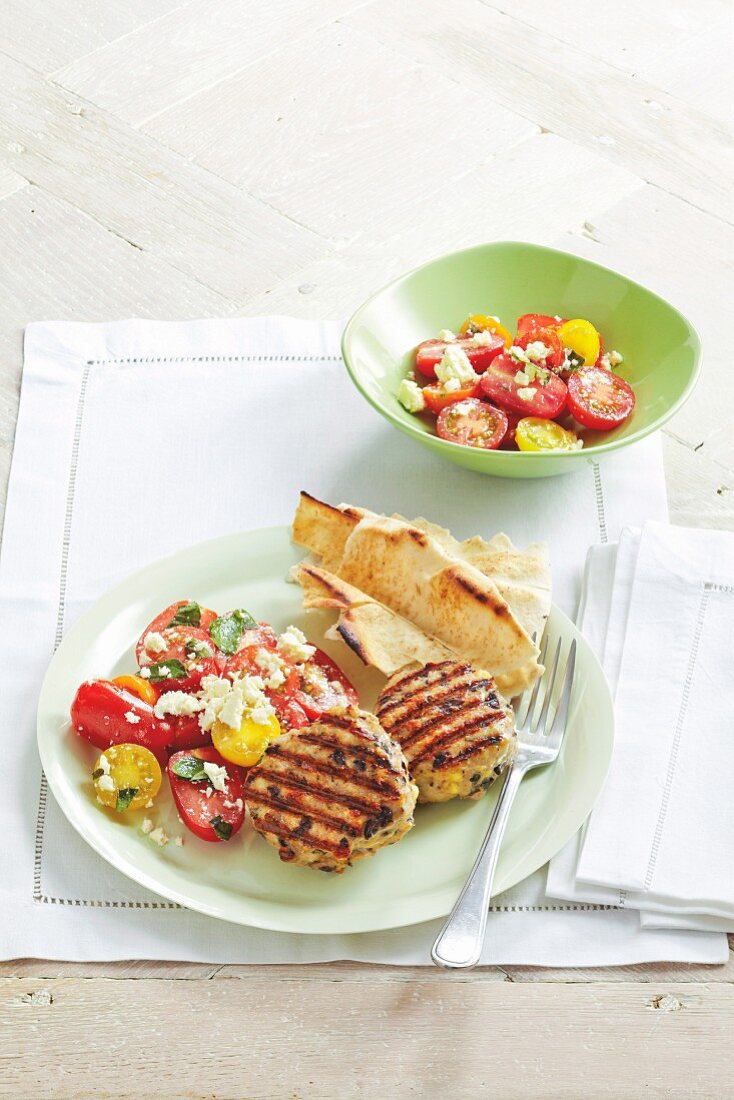 Grilled chicken burgers with olives and tomato salad (Greece)