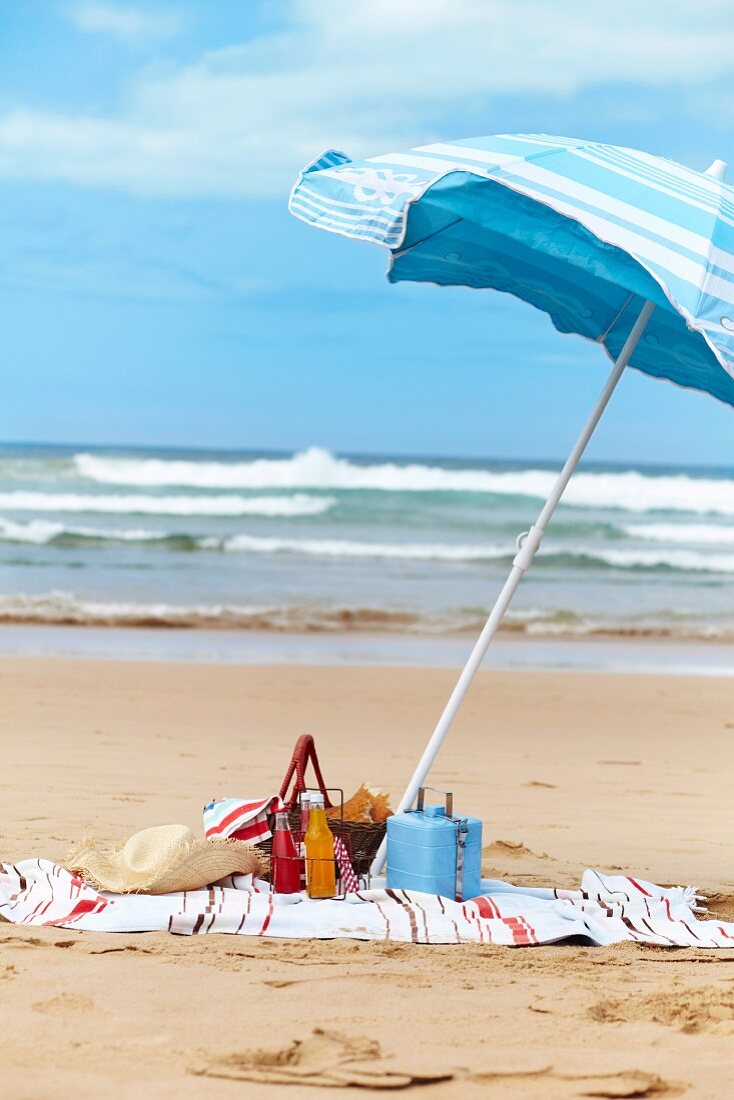 A picnic on a sandy beach with a sunshade