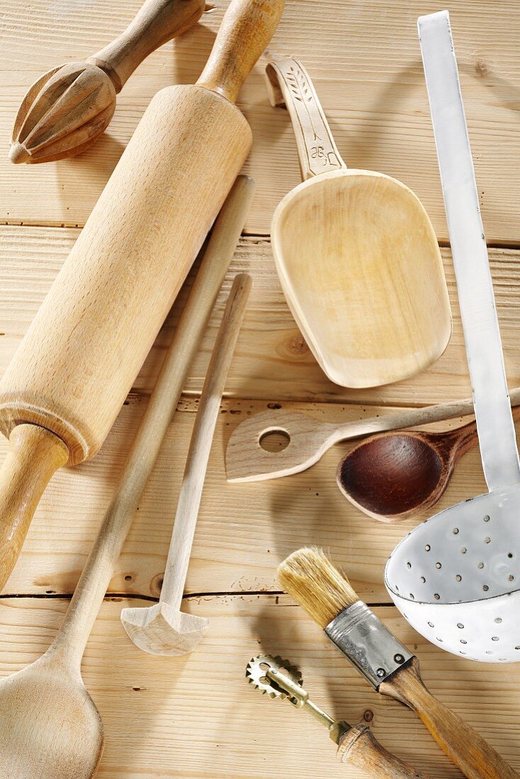 Kitchen utensils on a pale wooden surface