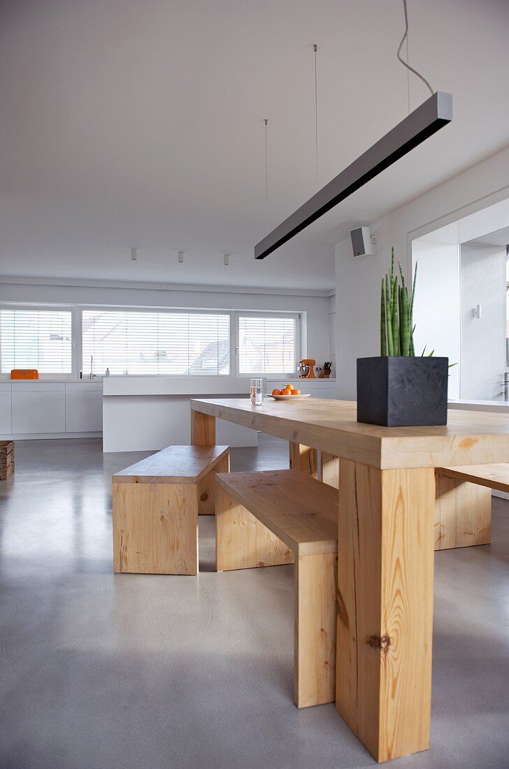 Minimalistischer Tisch mit Bänken aus Holz in modernem Wohnraum
