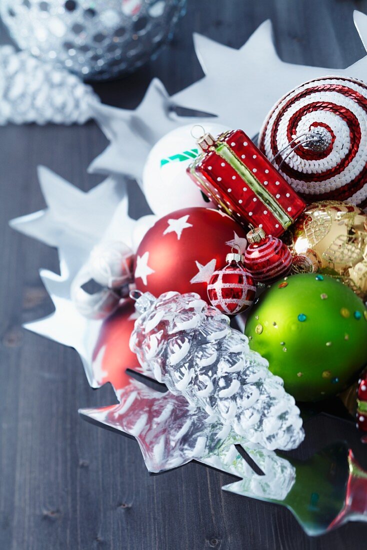 Mit bunten Weihnachtsanhängern gefüllte Sternenschale