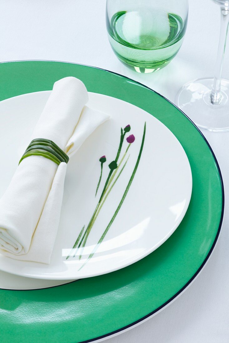 A plate decorated with a chive motif and a napkin with chives for a napkin ring